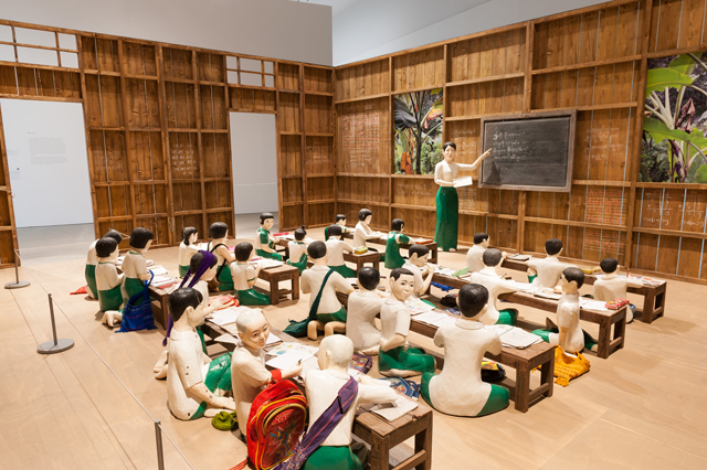 NGE Lay. The sick classroom, 2013. 27 wooden sculptures, timber walls, eight desks, 26 student accessories, one table, one chair; 15 photographs. Installation view, The 8th Asia Pacific Triennial of Contemporary Art, 2015. Collection: Queensland Art Gallery.